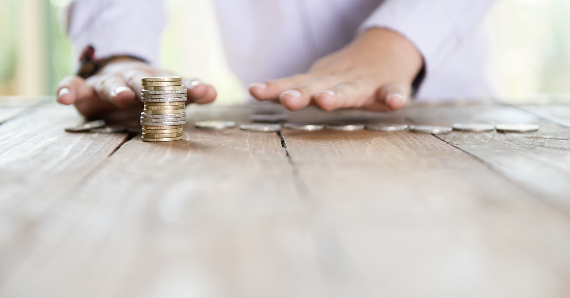 man counting coins on table