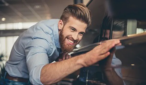 Man standing next to shiny new car