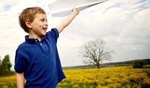 boy standing with paper plane