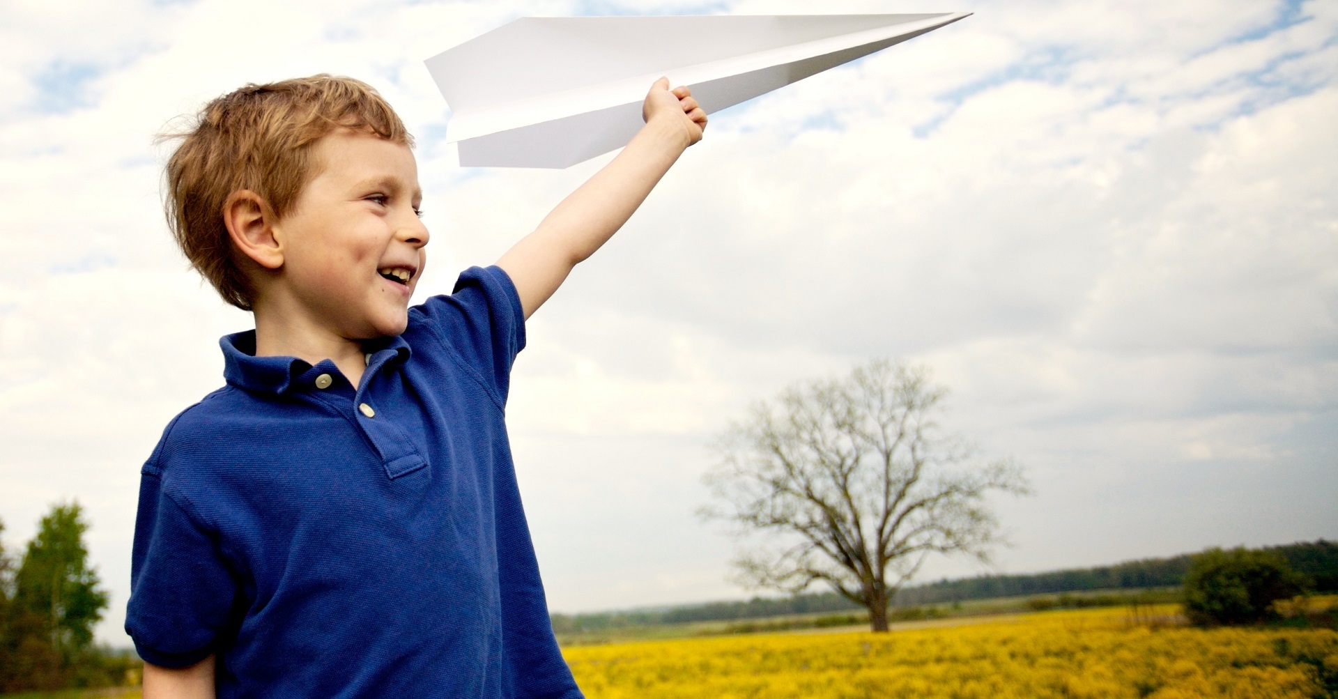 boy standing with paper plane