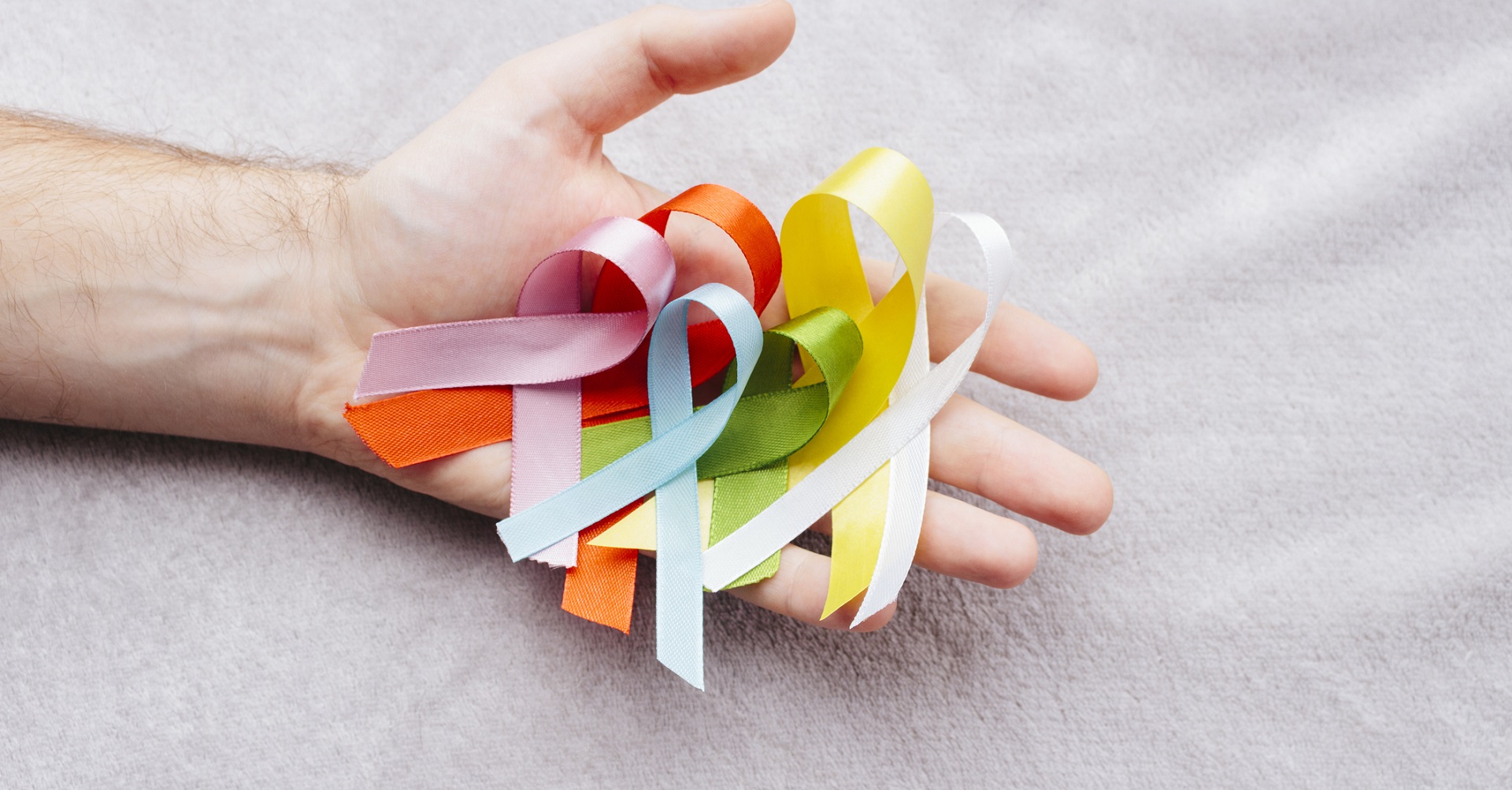 hand holding cancer ribbons