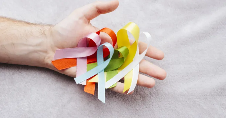 hand holding cancer ribbons