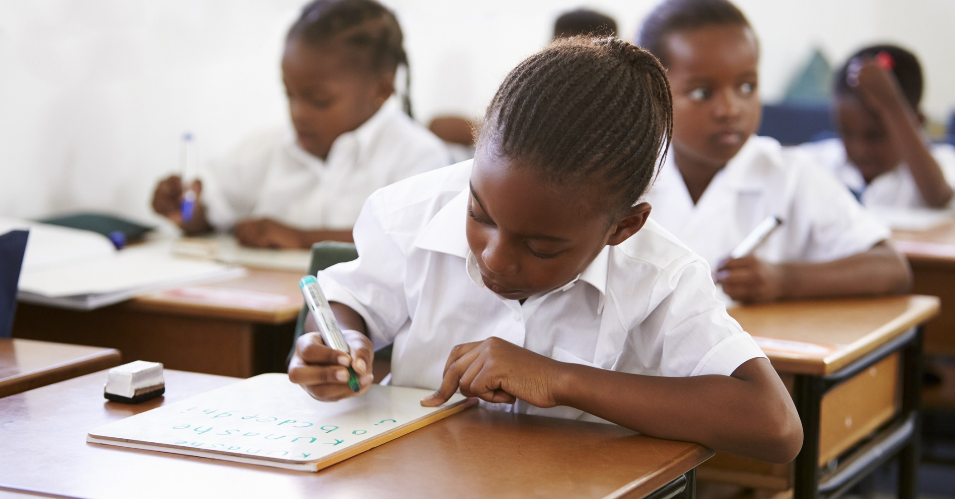 little girl sitting at school desk