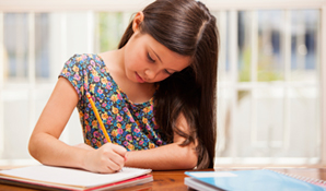 Girl sitting at table doing homework