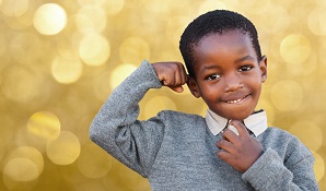 Little school boy showing off muscles