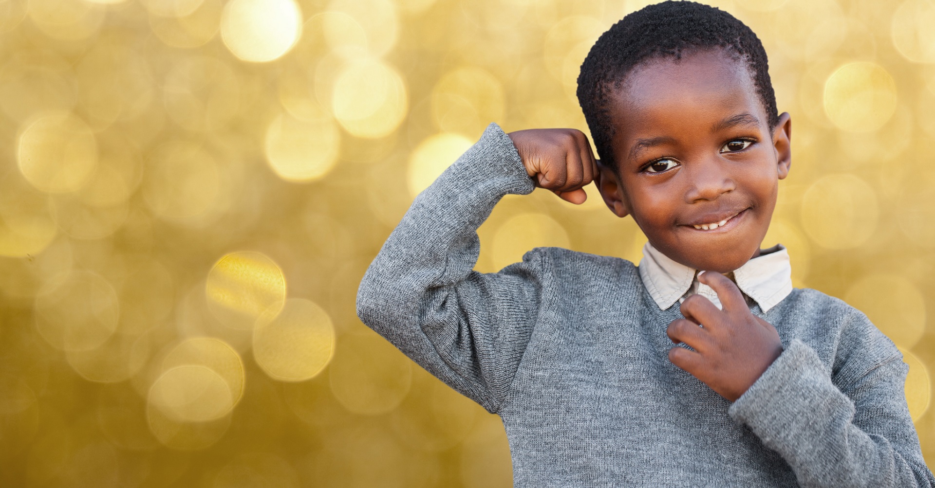 Little school boy showing off muscles