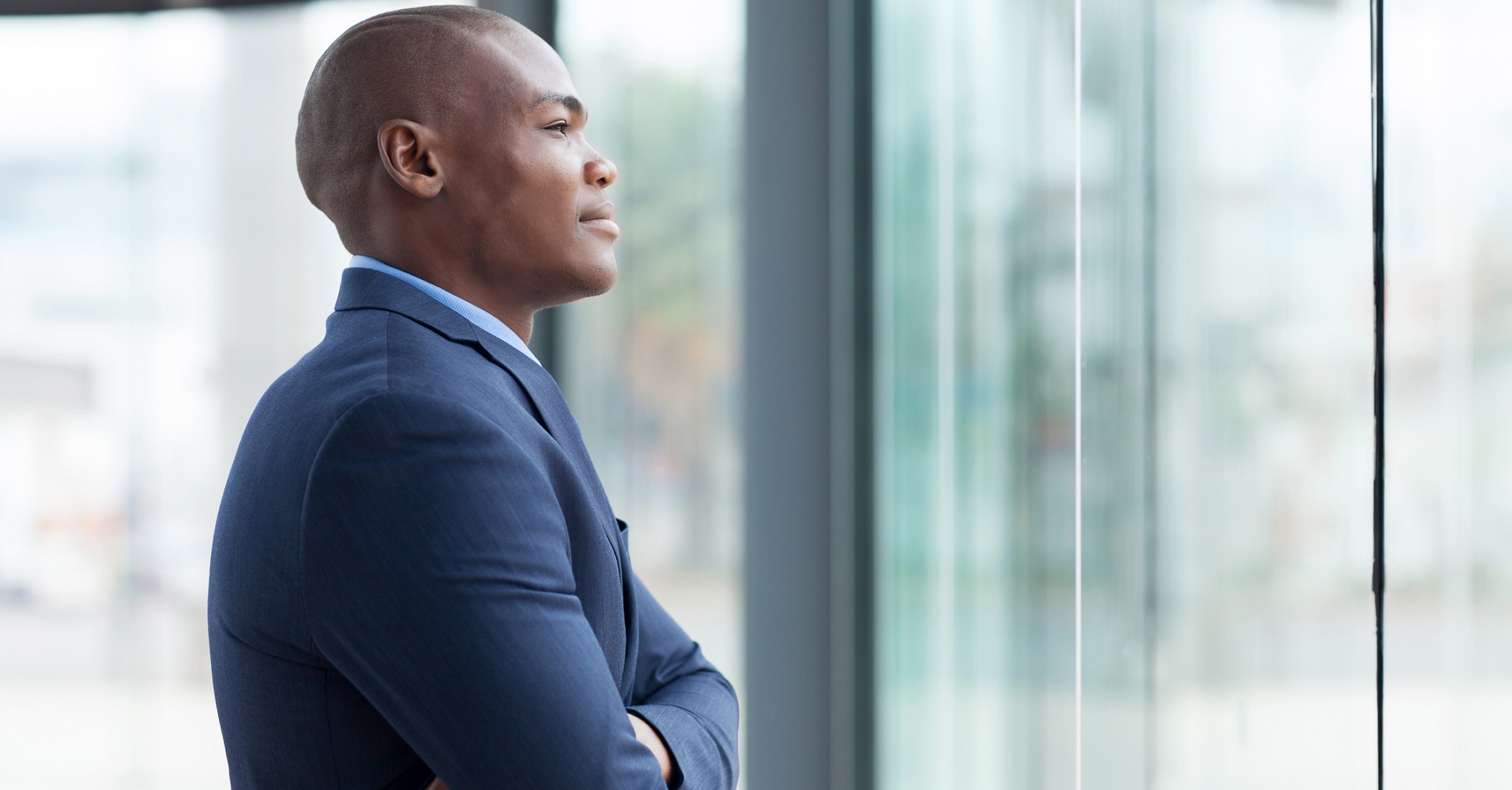 man in business suit staring outside window