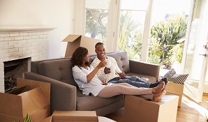 couple sitting in new house with boxes