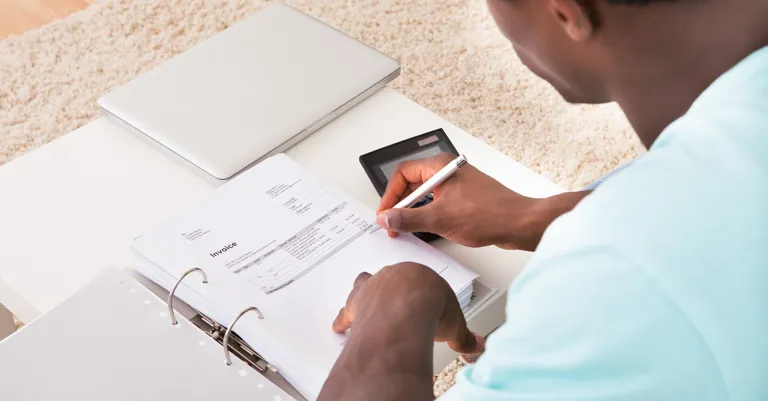 man sitting at table working out finances