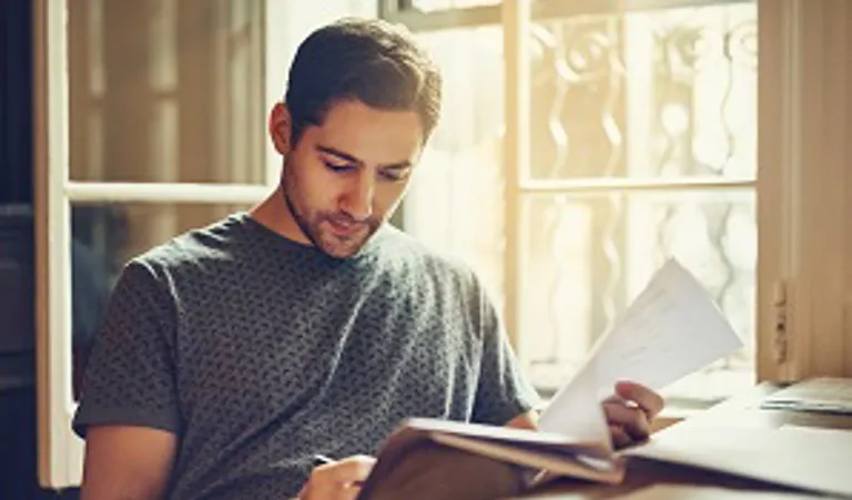 man sitting at desk with papers