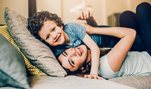 Mom lying on couch hugging son