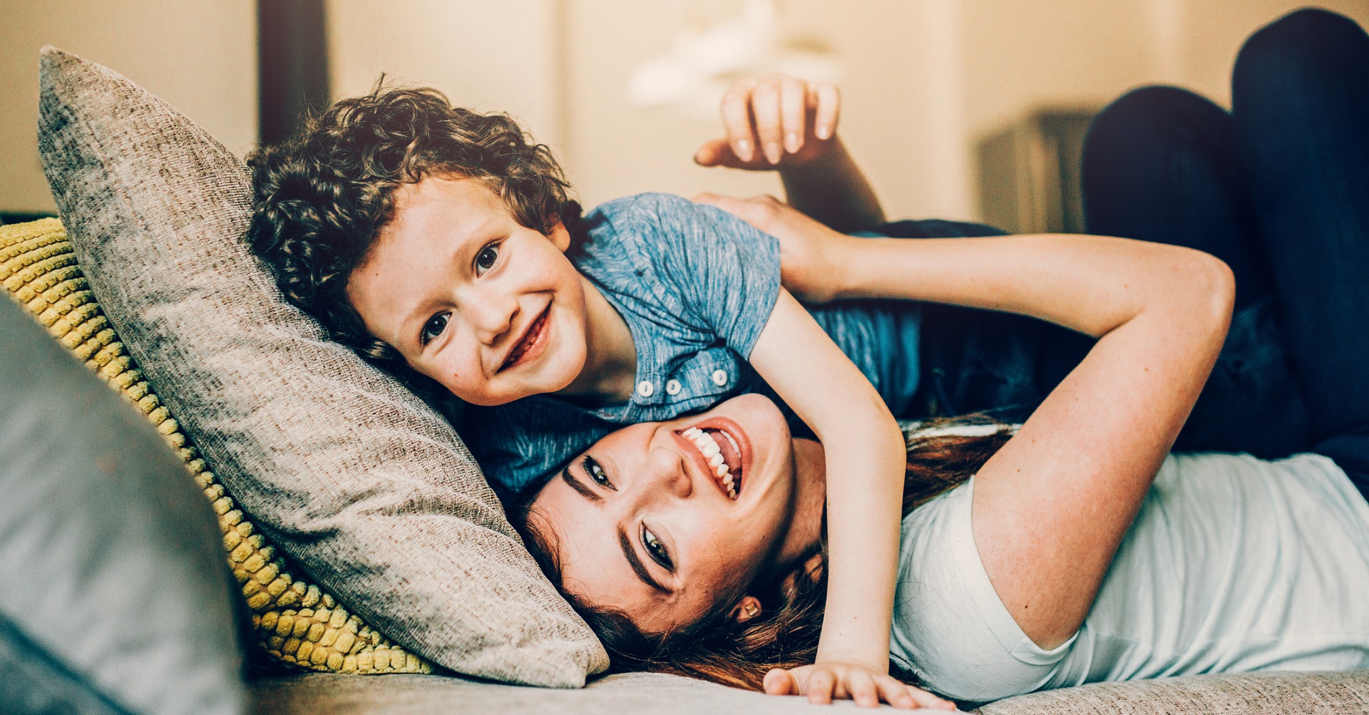 Mom lying on couch hugging son