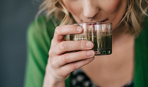 woman drinking a healthy green drink