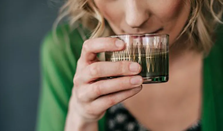 woman drinking a healthy green drink