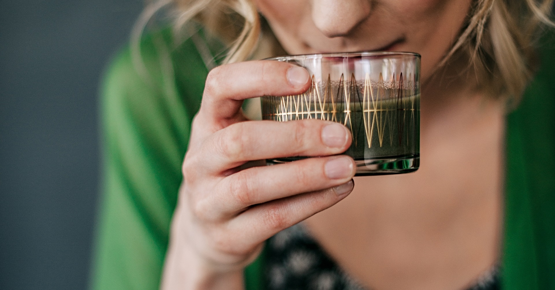 woman drinking a healthy green drink