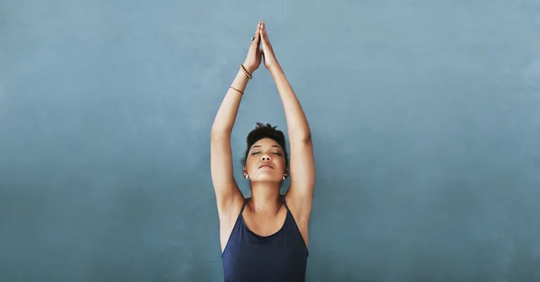 healthy woman standing with arms in air