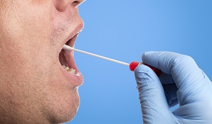 Man swabbing mouth with testing kit