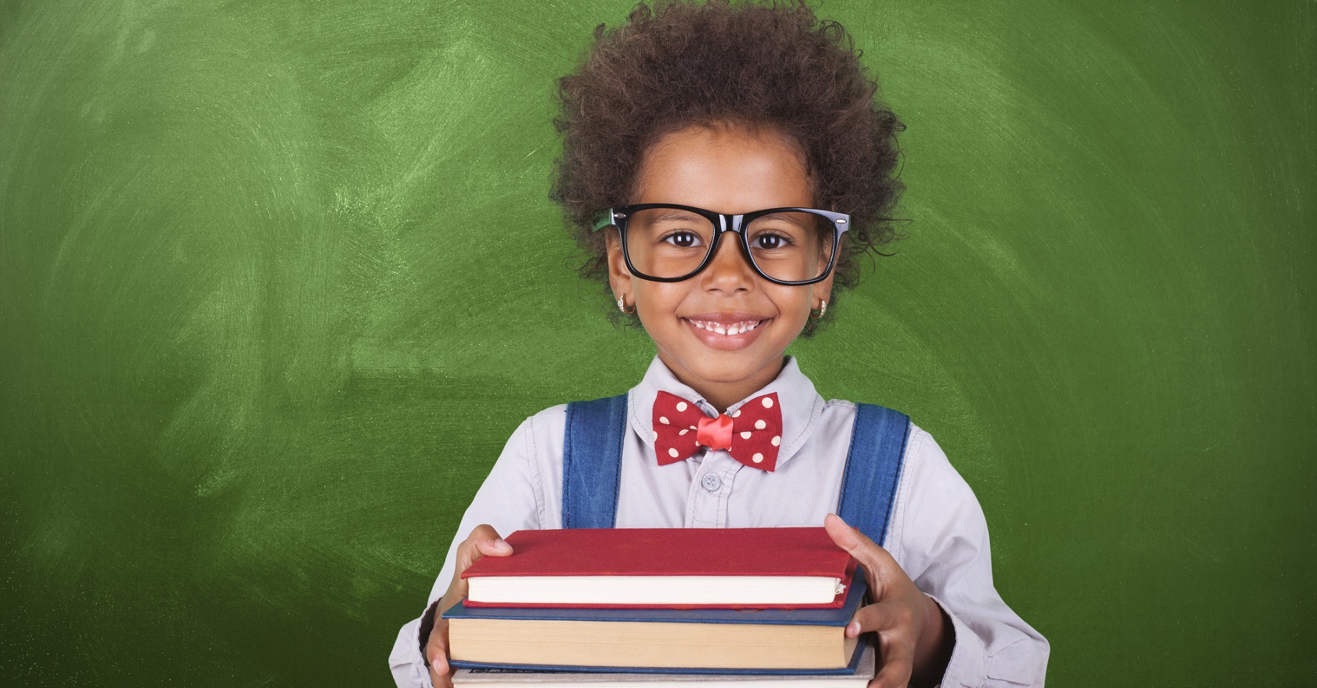 child with glasses holding school books