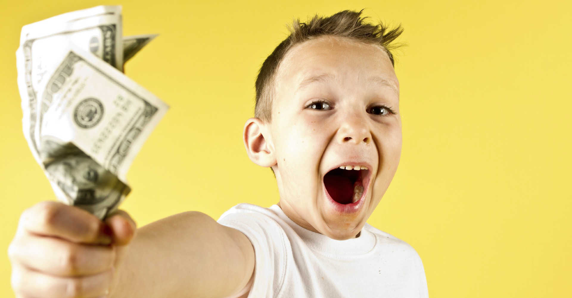 kid holding money with excitement on face