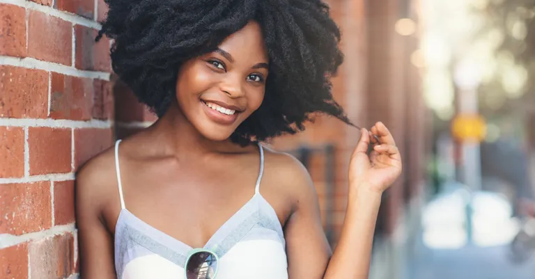 happy woman leaning against wall
