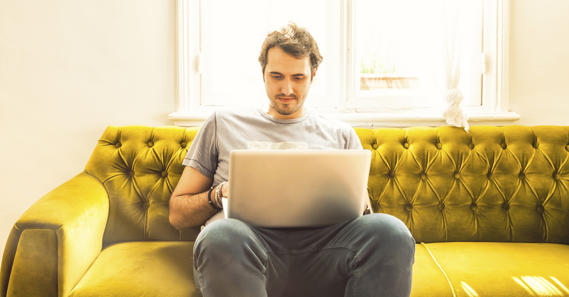 man sitting on couch with laptop