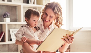 Woman on bed with daughter reading book