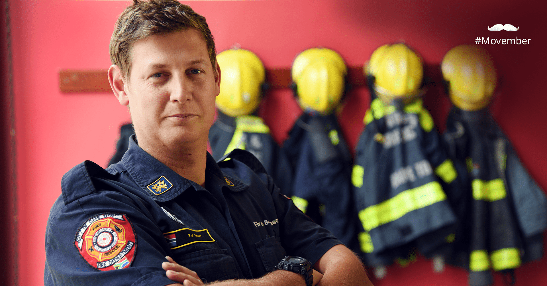 Image of man standing in front of firemen uniforms