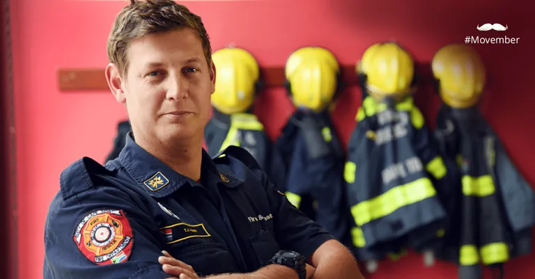 Image of man standing in front of firemen uniforms