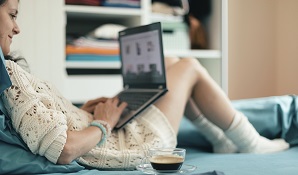 woman sitting on bed with laptop