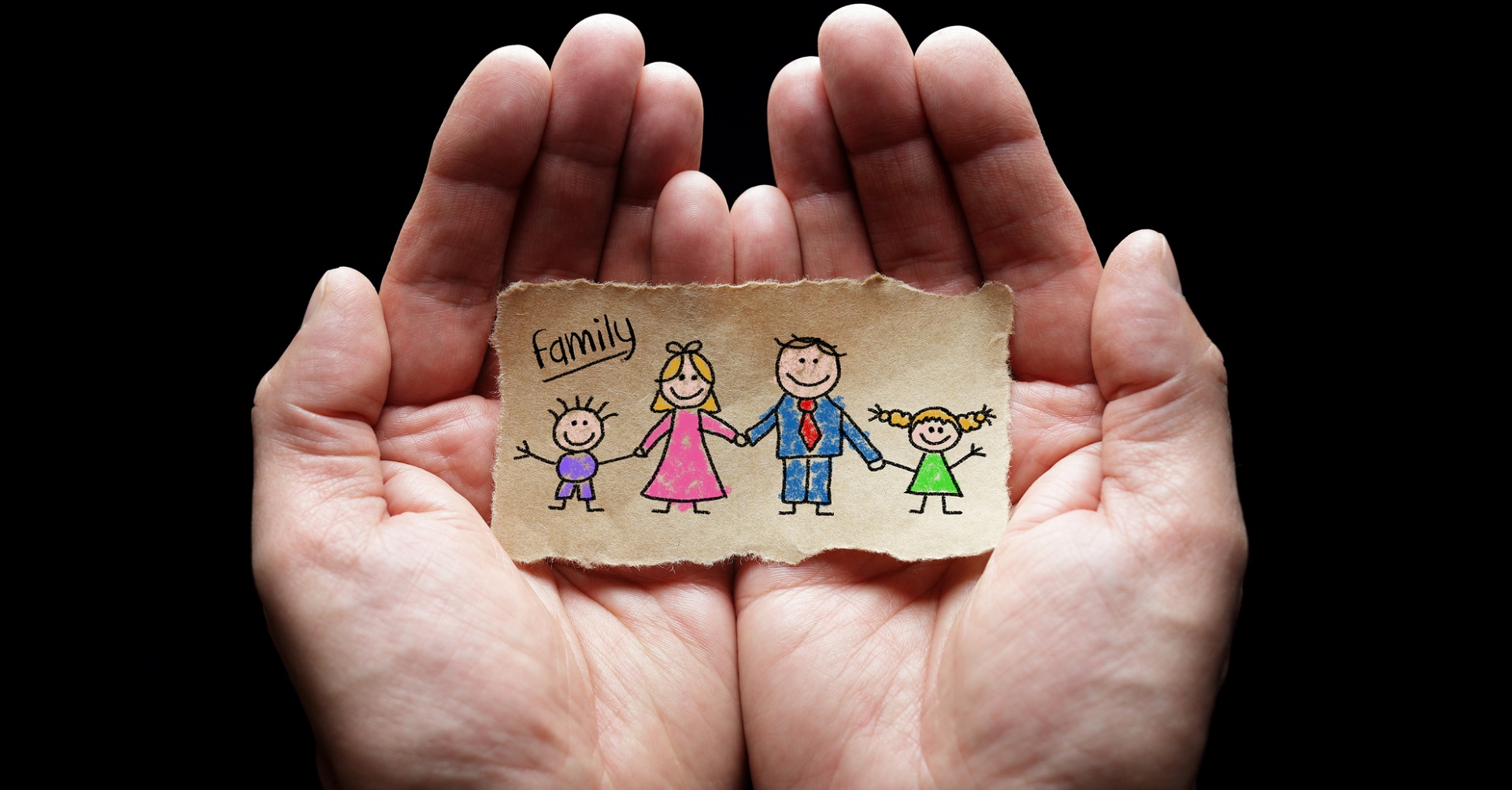 Hands holding paper cut out of family