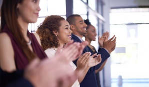 Group of colleagues standing together and clapping