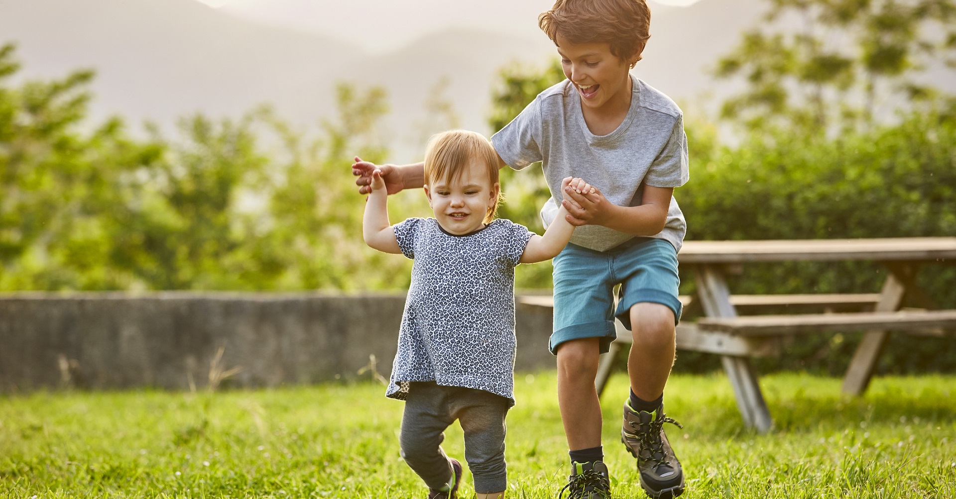 little boy playing with his sister in the garden