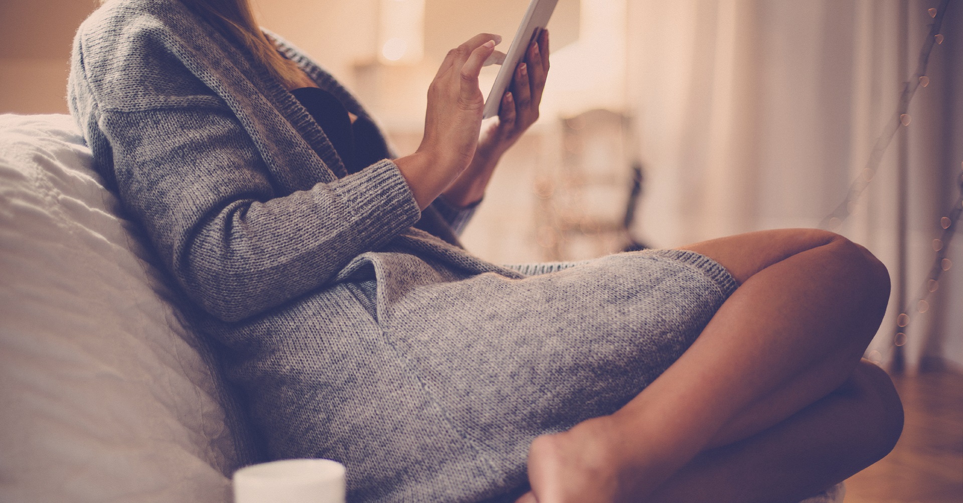 woman sitting on couch with tablet