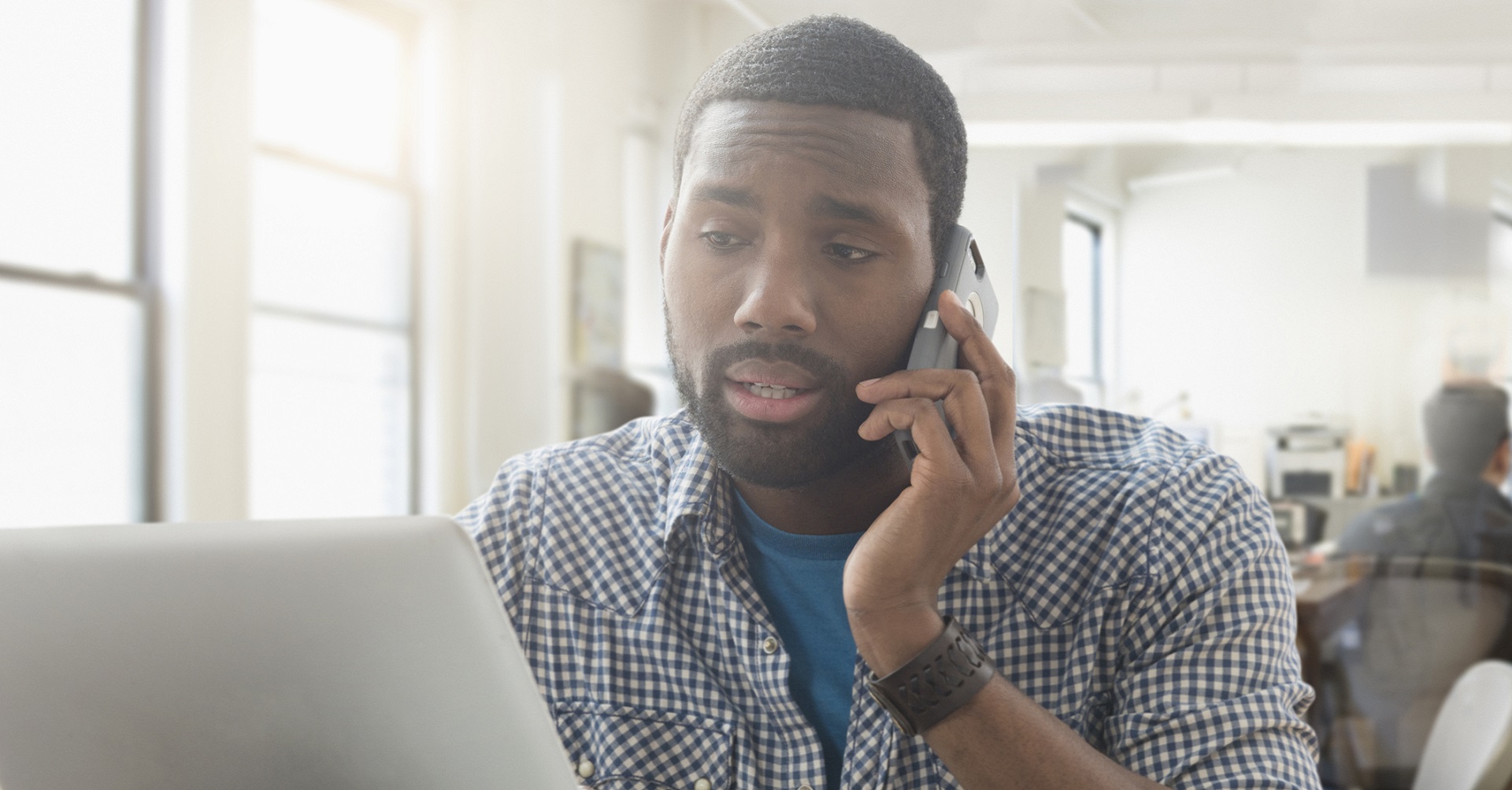 man sitting at laptop looking concerned