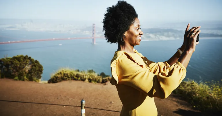 woman taking photos by golden gate bridge