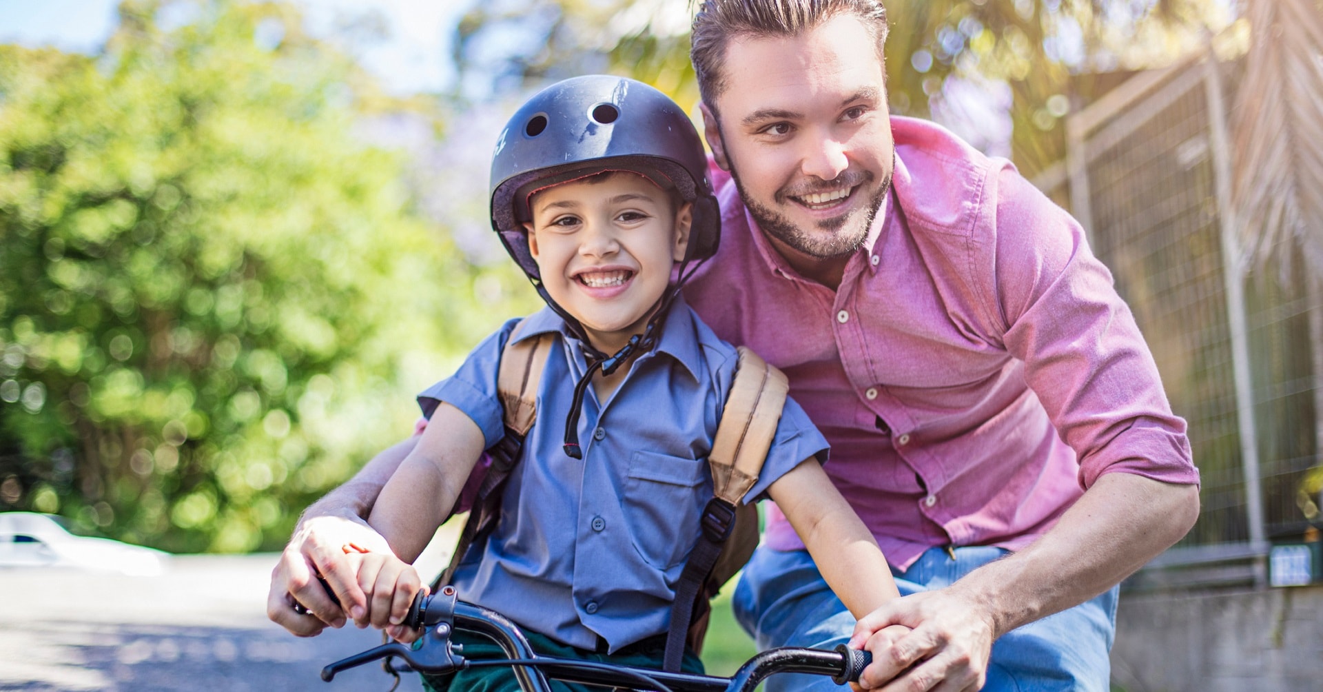 father teaching child to ride a bike