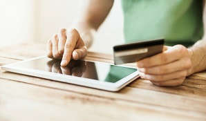 man with tablet & bank card on table