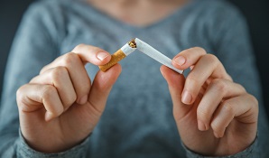 woman breaking cigarette in half