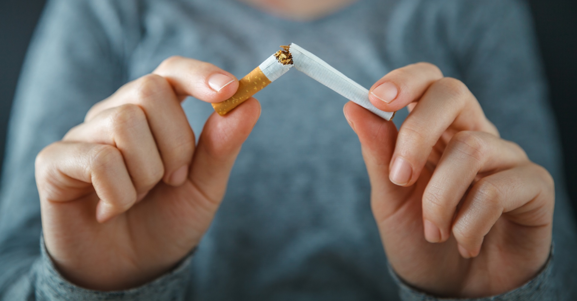 woman breaking cigarette in half