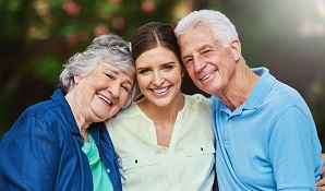 Young lady hugging elderly parents