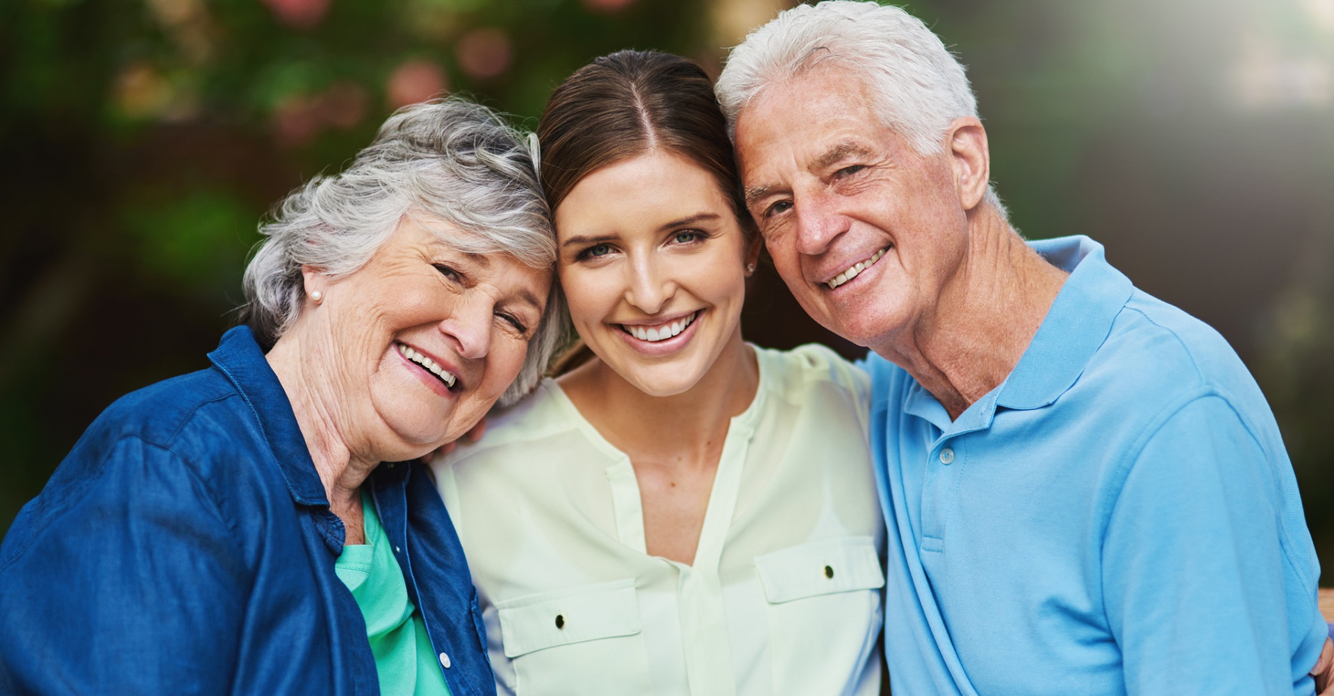 Young lady hugging elderly parents