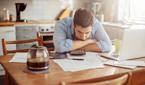 man sitting at desk looking worried