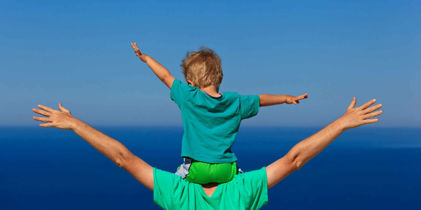 child flying on father's shoulders