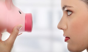 woman looking at piggy bank