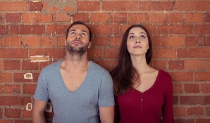 couple standing against wall looking up