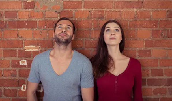 couple standing against wall looking up