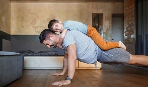 Man doing push-ups with son on back