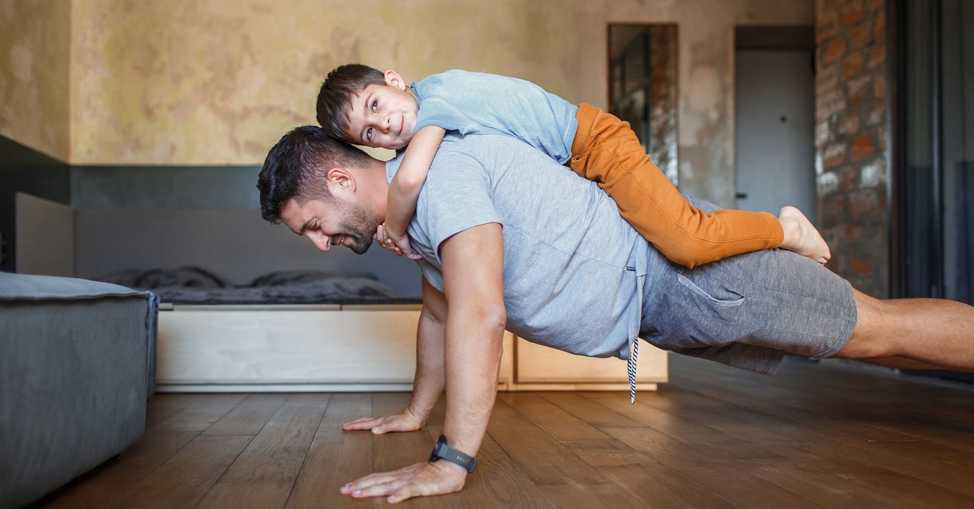 Man doing push-ups with son on back
